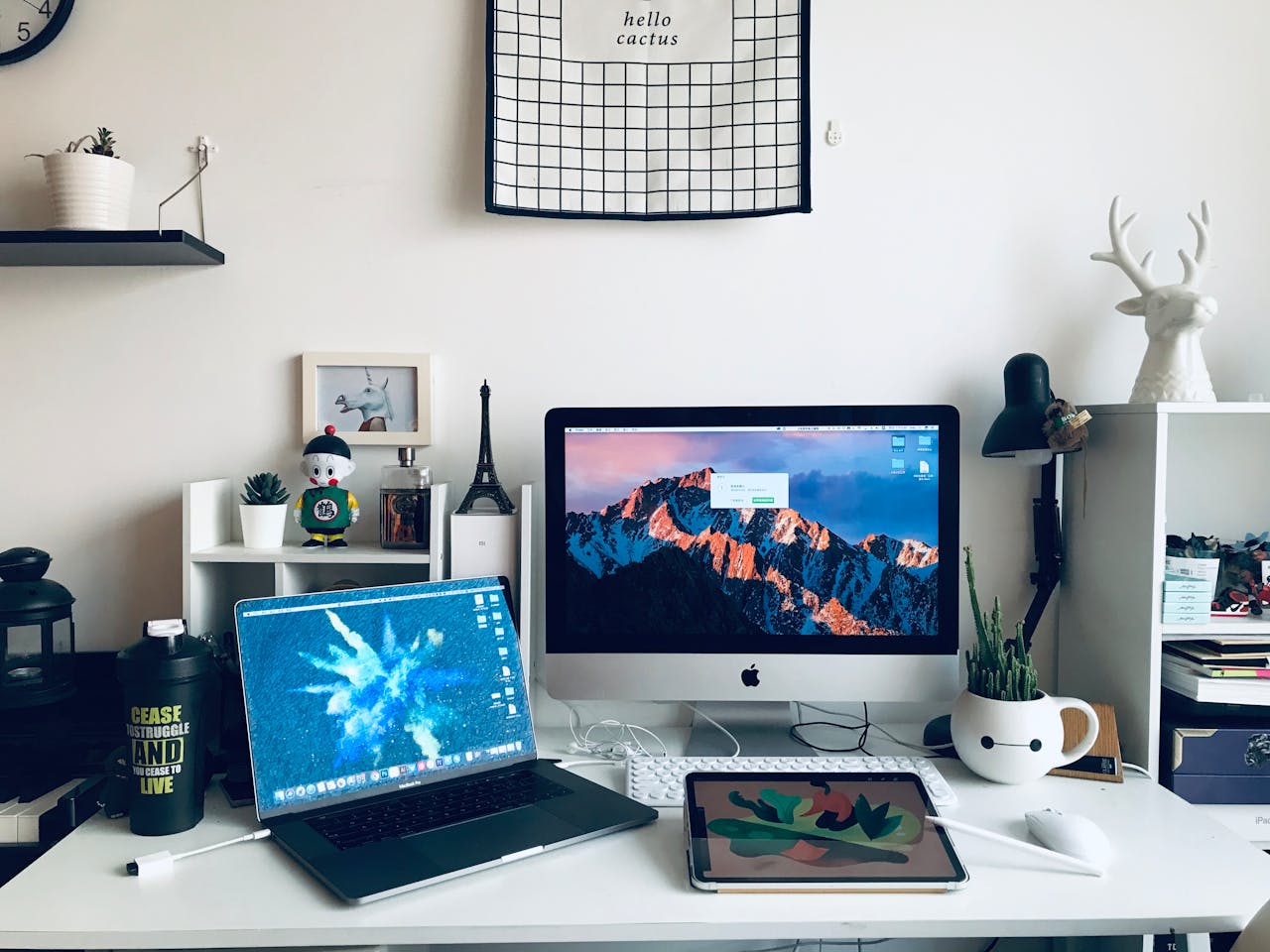 A stylish home office featuring a laptop, desktop, and artistic decor elements for a productive workspace.